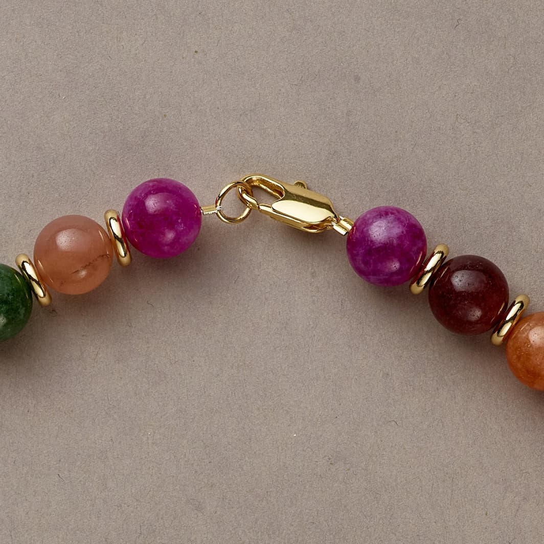 Close-up of Rainbow Vibe beads, featuring vibrant pink, green, blue, and gold tones with delicate silver spacers.