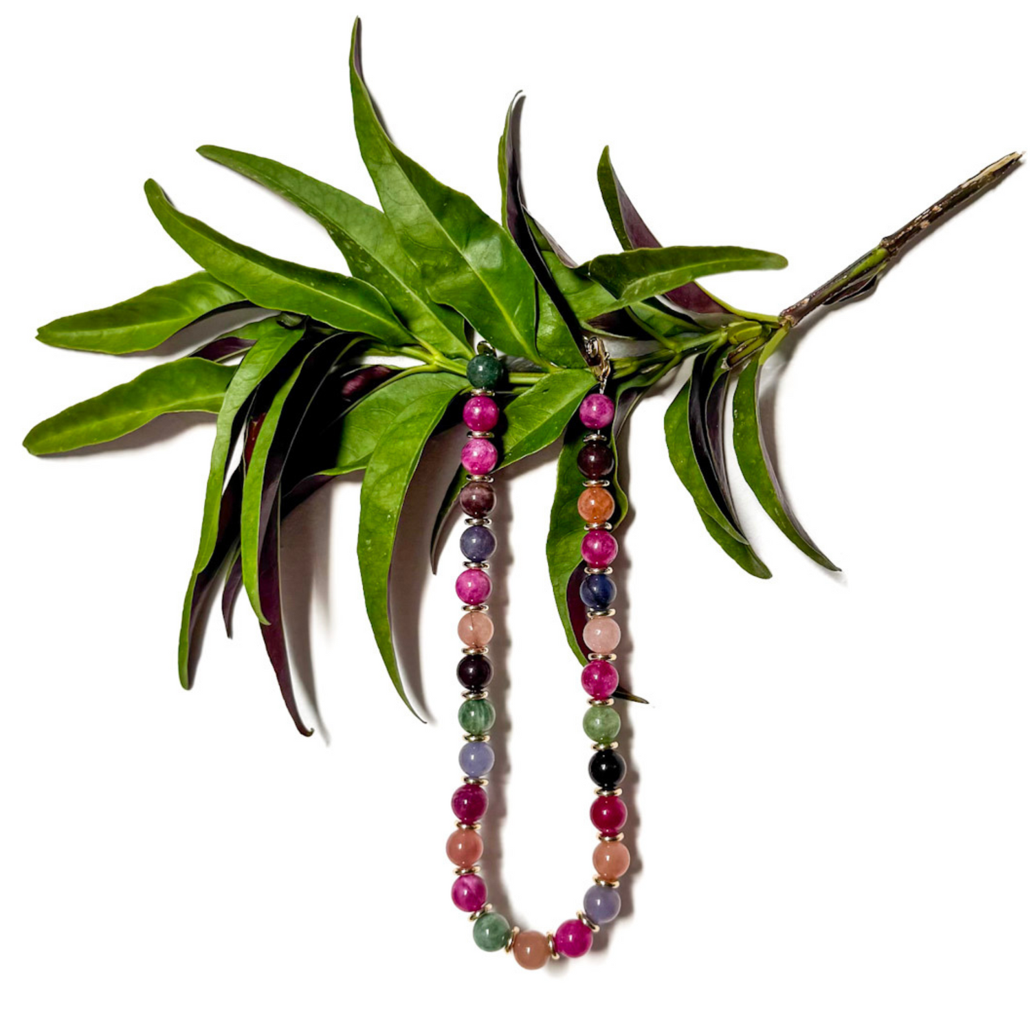 colorful stones beaded necklace on a branch and a white background