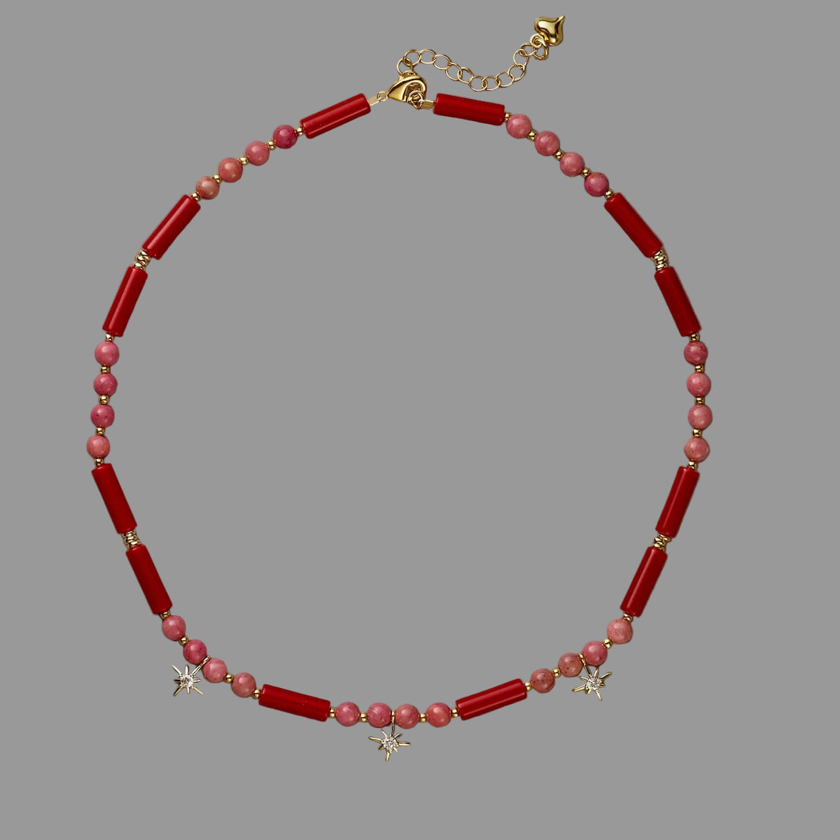 Necklace with red and pink beads on a beige background