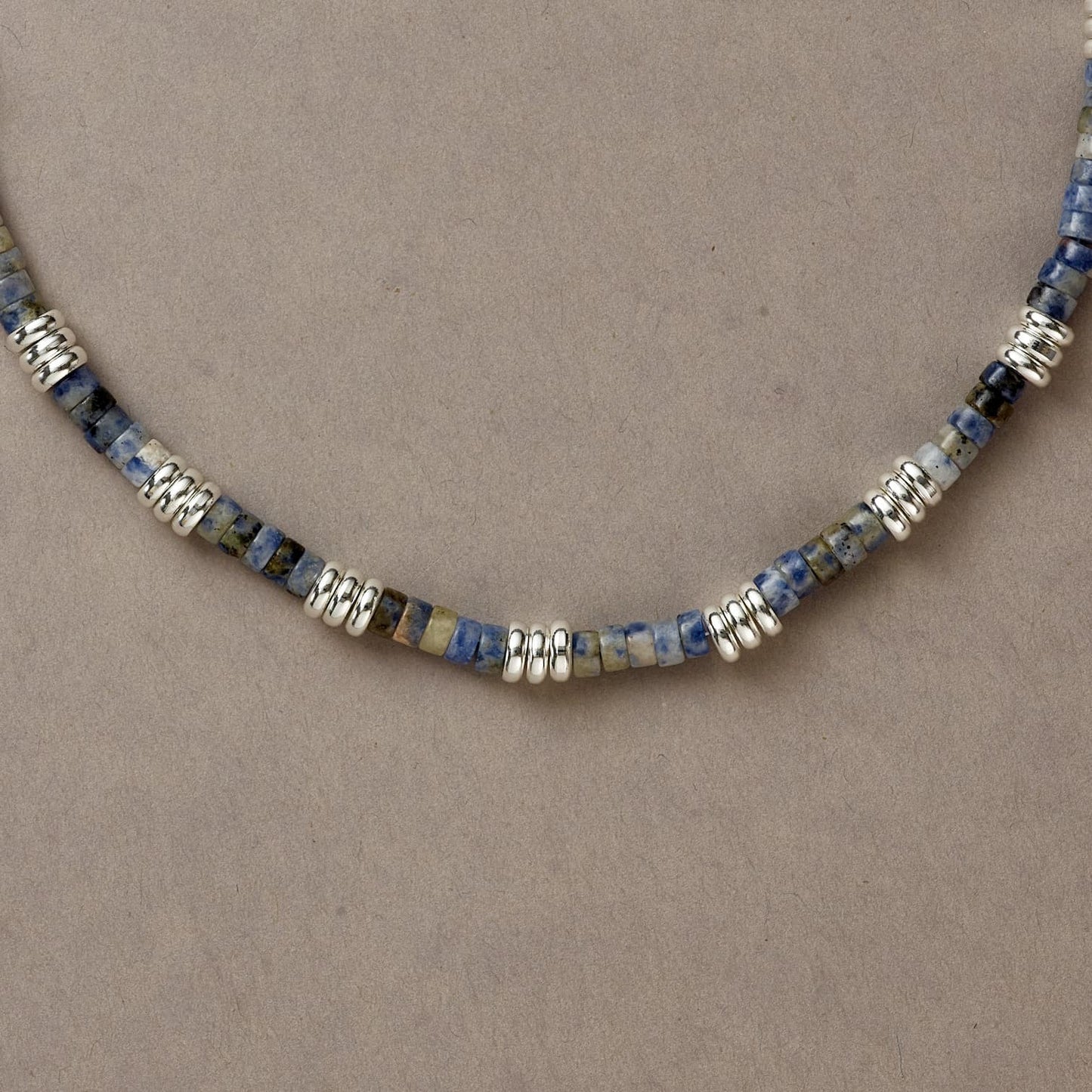Side detail of Blue Mind necklace with rich-toned blue Sodalite and silver beads arranged symmetrically.