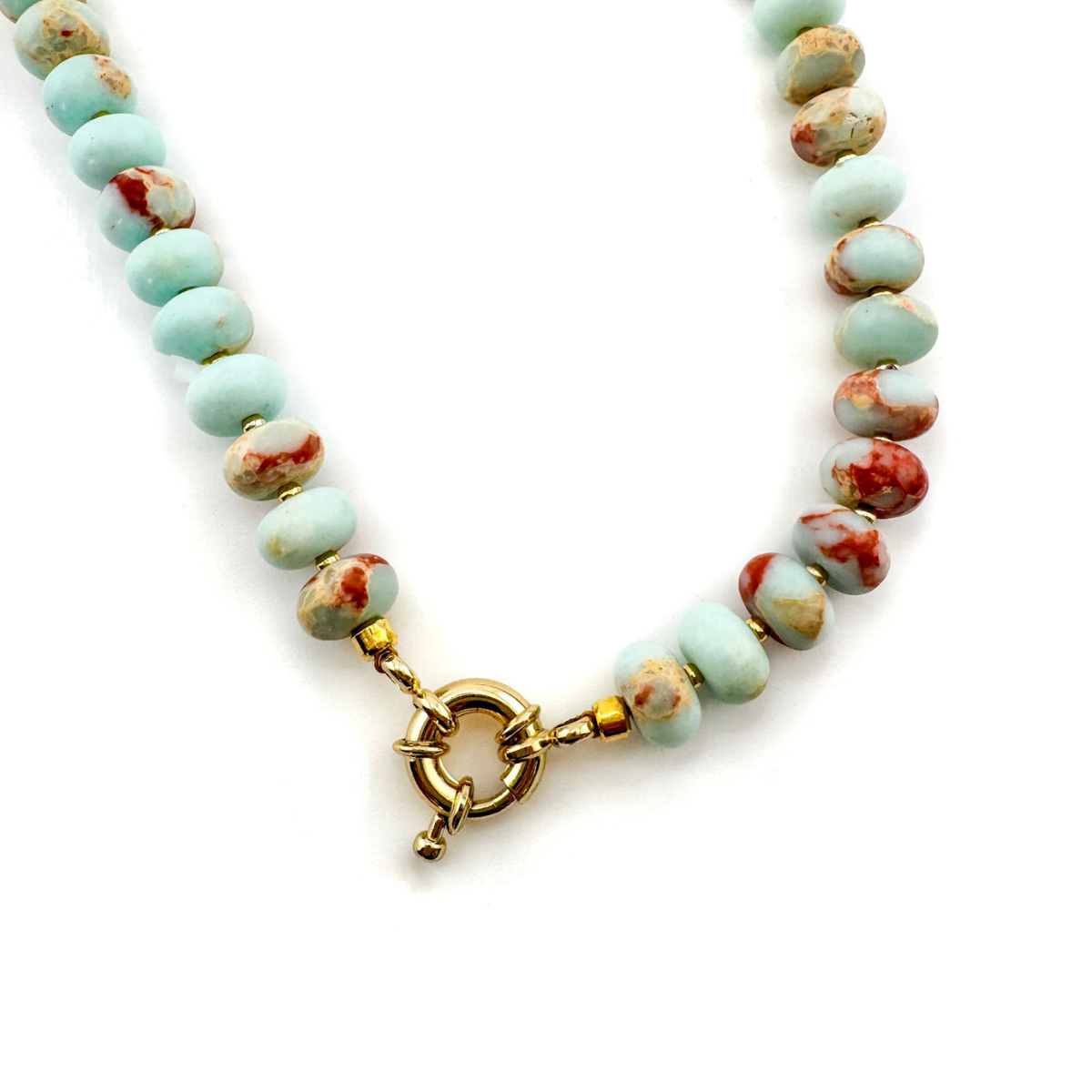 Necklace with turquoise and red beads and a gold clasp on a white background