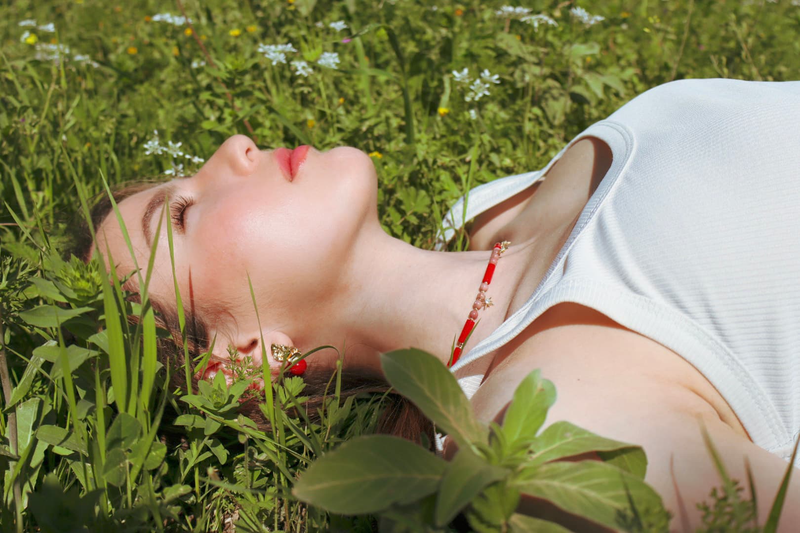 Woman lying in a grassy field with flowers