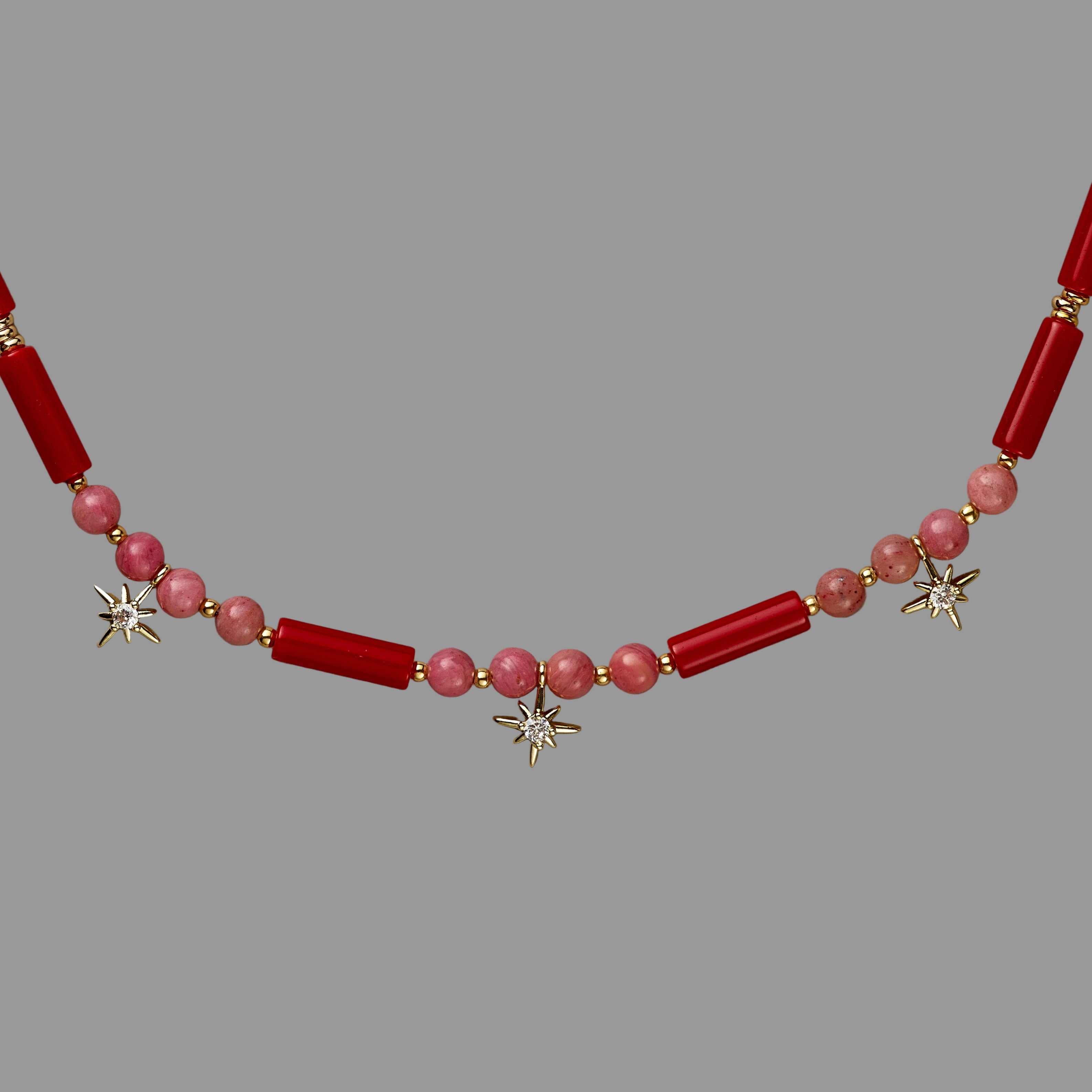 Necklace with red and pink beads on a beige background