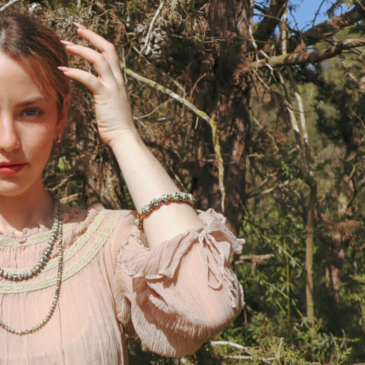 Woman in a natural setting with trees and greenery