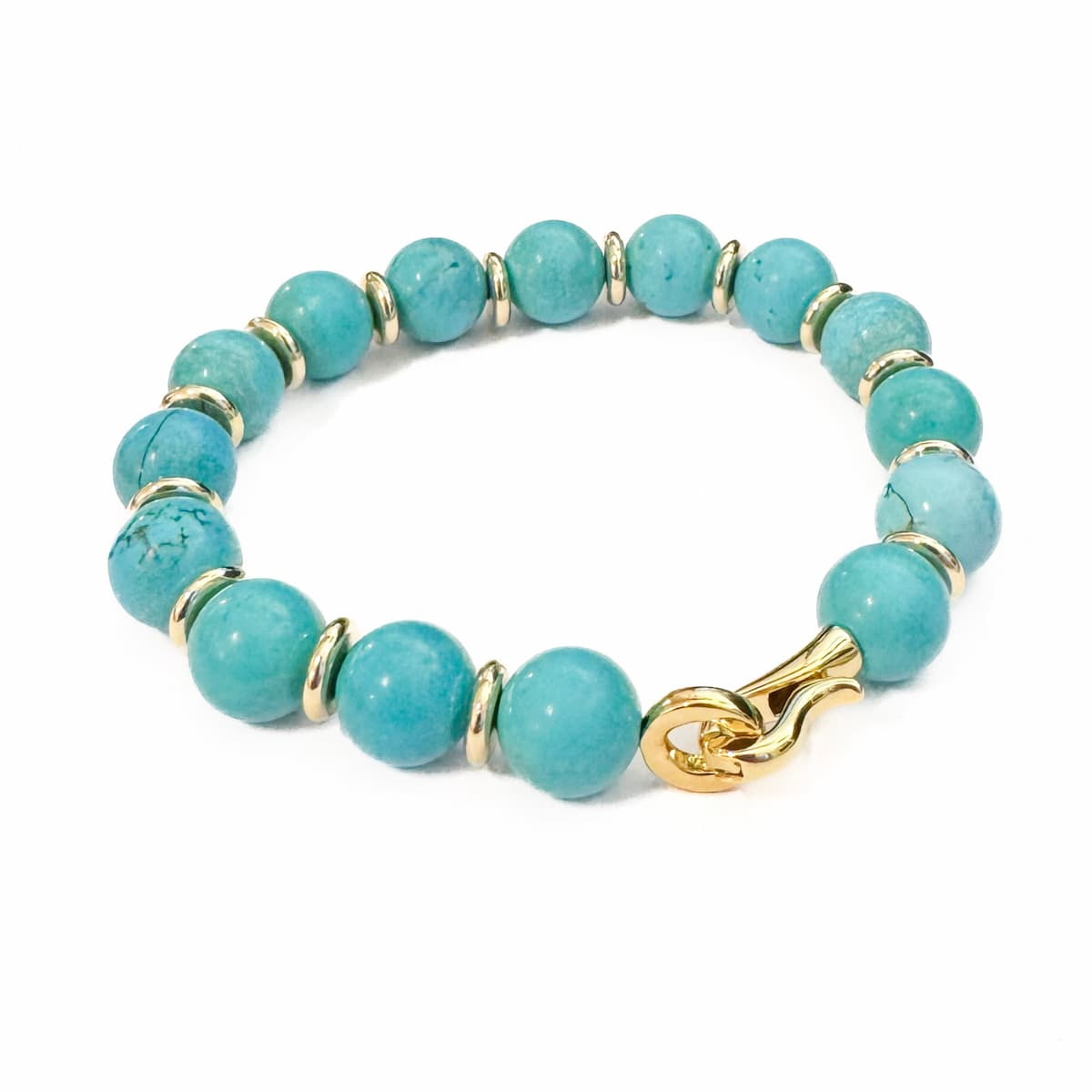 Turquoise beaded bracelet with gold accents on a white background