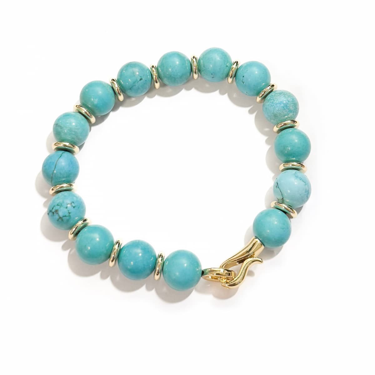 Turquoise beaded bracelet with gold accents on a white background