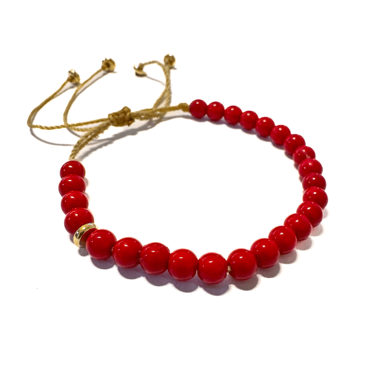 תקריב על צמיד אלמוג אדום של Mella Jewelry על רקע בהיר